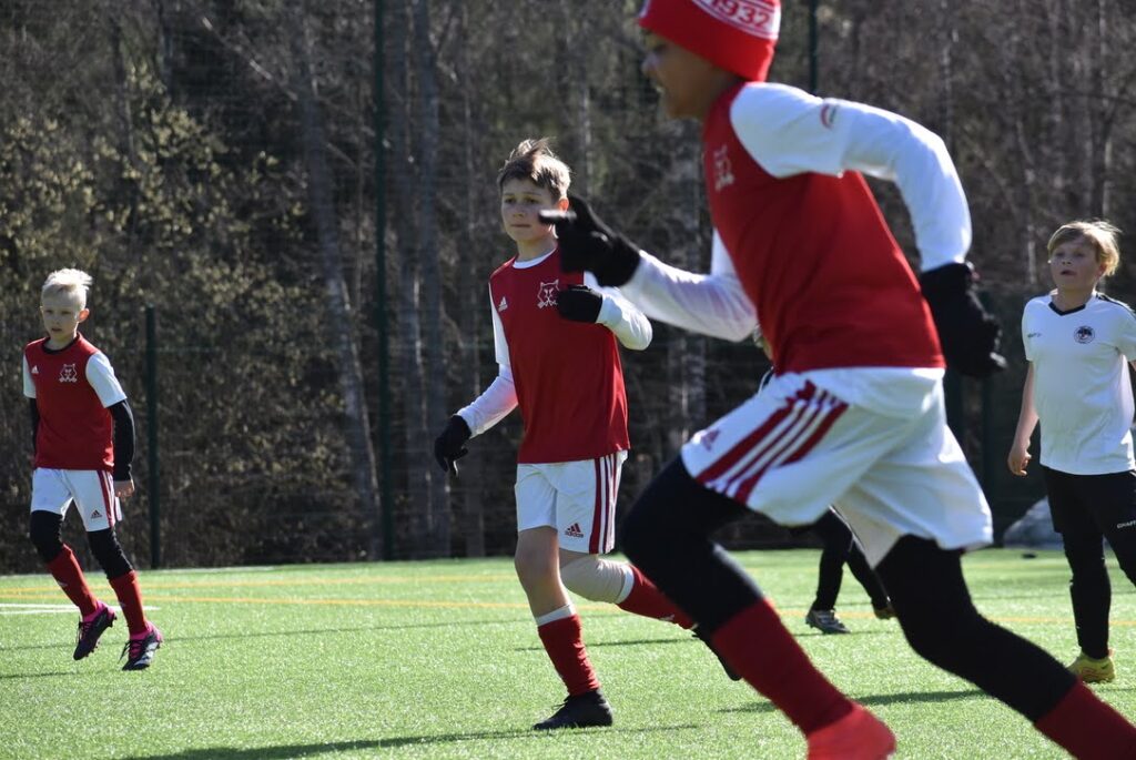 pojat juoksevat jalkapallokentällä pelissä