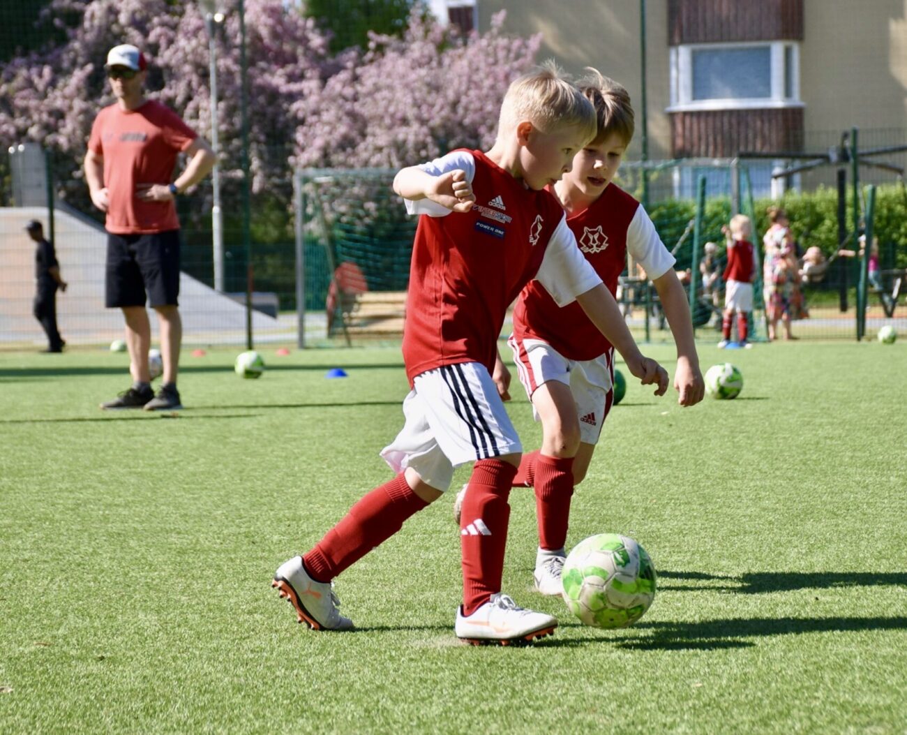junioripelaajia kentällä pelaamassa jalkapalloa